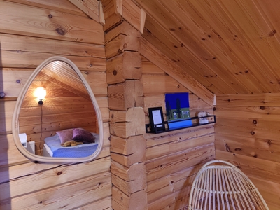 Wooden room with rattan armchair and bed at Koli Runo bed and breakfast