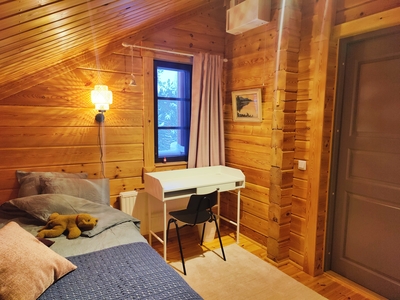 Small wooden room with bed and desk at Koli Runo bed and breakfast